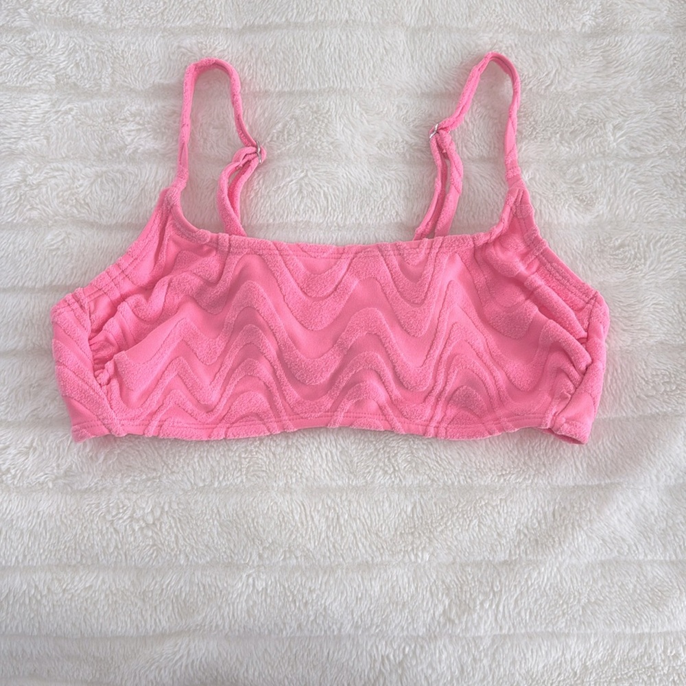 cute soft swimsuit top that is pink with wavy details on it. (xs)